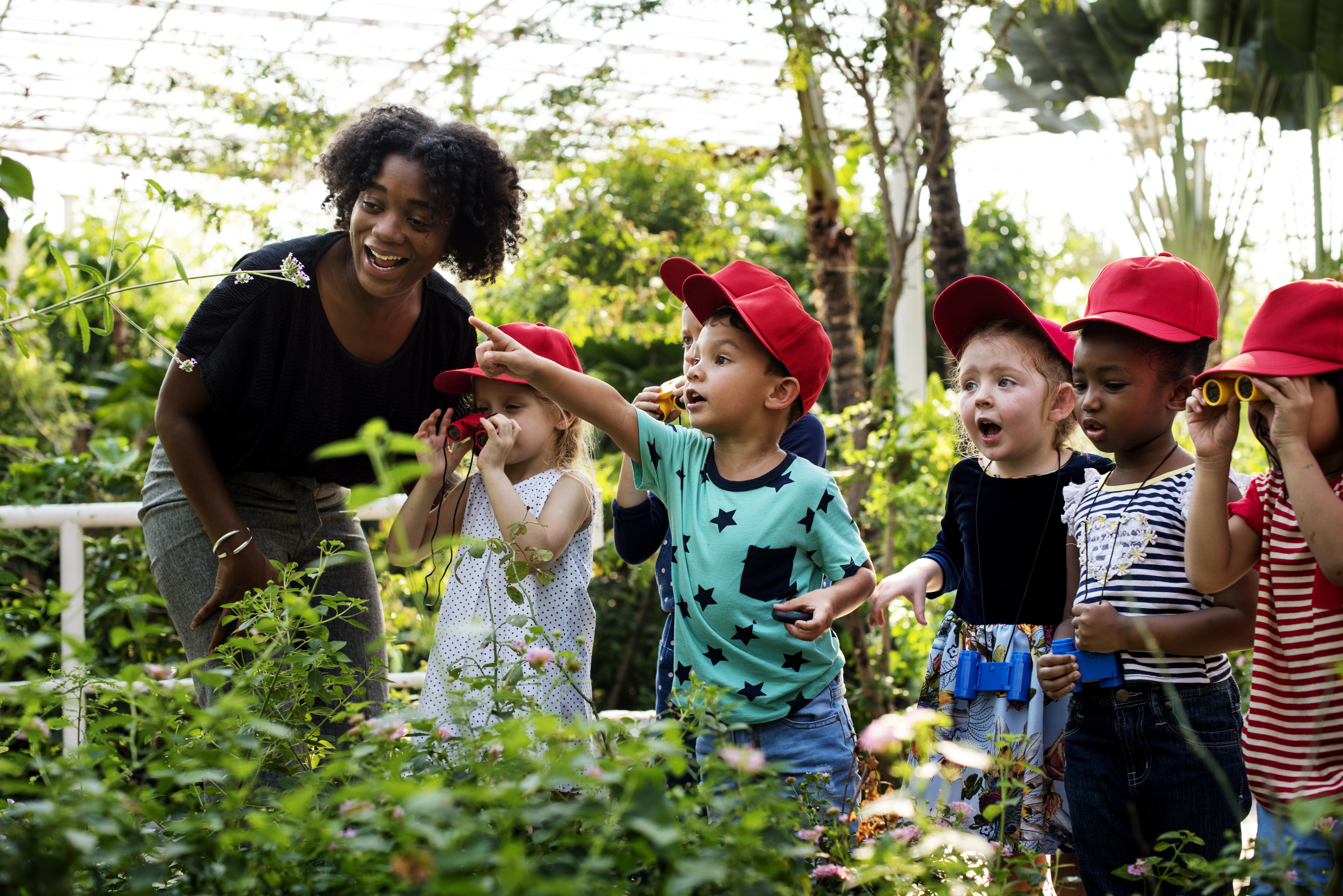 young children and an adult surrounded by nature