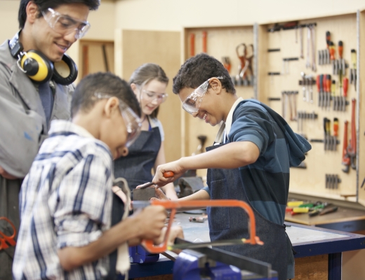 Adult and children working in a woodshop
